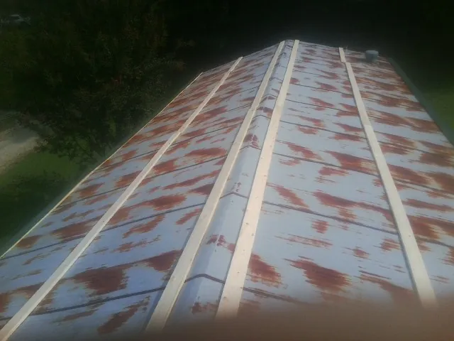 Rusted metal roof panels with new wood purlins before replacement — Storm Damage Roof Repair in Sewanee by Roofing Brothers