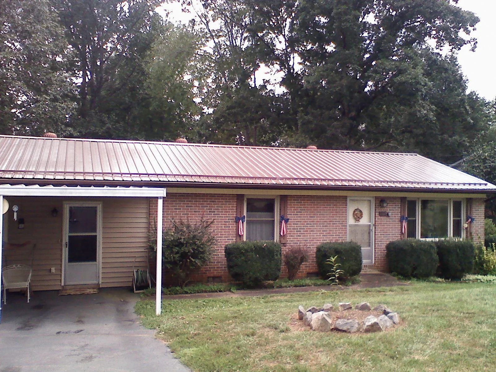Bronze metal roof and carport on a brick ranch home — Roof Repair work by our crew in Sewanee