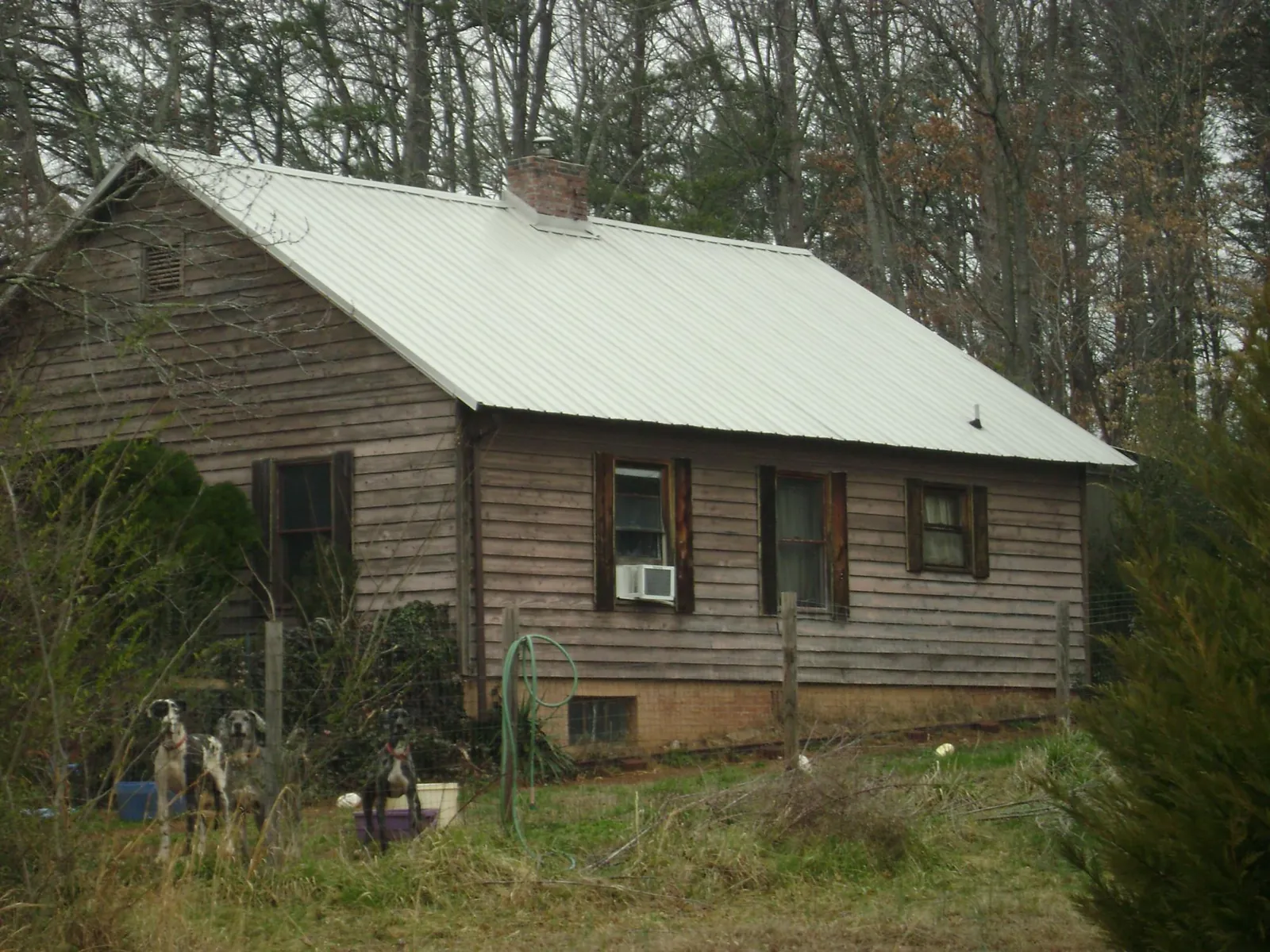 White metal roof on an old wood sided farmhouse, from a Metal Roof Installation job in Sewanee